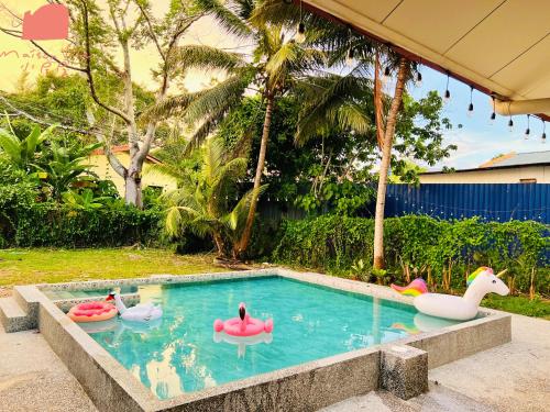 a swimming pool with three inflatable ducks and swans at Maison Life 小居屋 Holiday Home Kota Kinabalu in Kota Kinabalu
