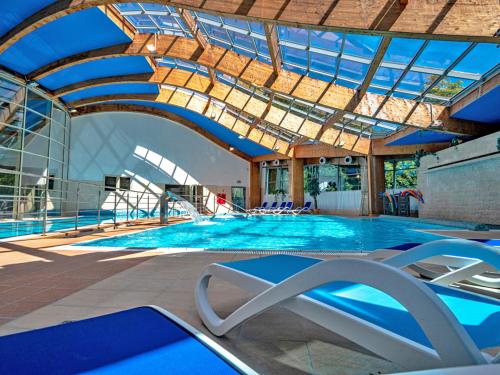 a large swimming pool with a glass ceiling at Alga Baltic Resort in Świnoujście