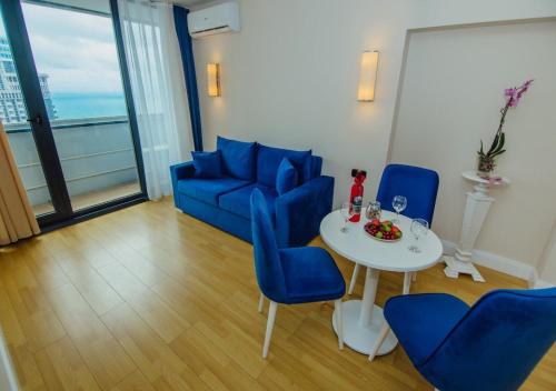ein Wohnzimmer mit einem blauen Sofa und einem Tisch in der Unterkunft KING DAVID & Orbi City Batumi in Batumi