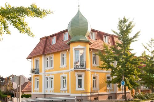 a yellow building with a turret on top of it at Villa Lucia in Hévíz