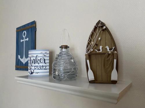 a shelf with a bottle and a box on it at Meer geht immer in Prerow