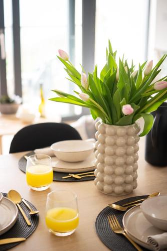 a vase of flowers sitting on a table with orange juice at The Penthouse in Hope-Cove