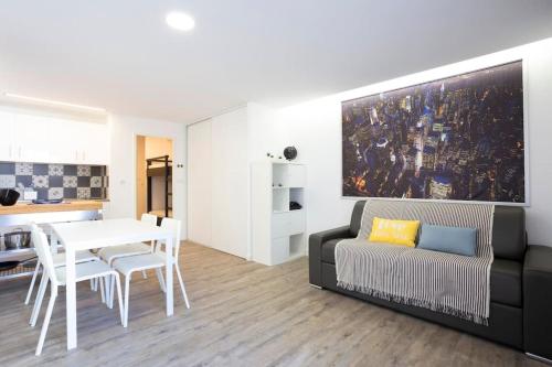 un salon avec un canapé et une table dans l'établissement Chez Aurélien - Magnifique studio design climatisé en centre ville avec parking, à La Grande Motte