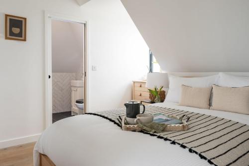 um quarto com uma cama branca e uma bandeja em The Penthouse em Hope-Cove
