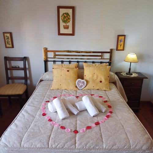 a bed with a heart made out of pillows at piso compartido con habitaciones independientes in Cerrillo de Maracena