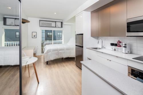 a kitchen and living room with a bed in a room at Micro Boutique Living Fredericton in Fredericton