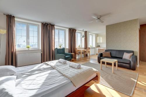 a bedroom with a large bed and a living room at Dom & House - Apartments Old Town Targ Rybny in Gdańsk