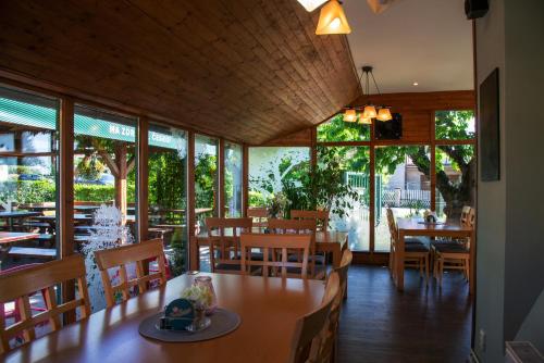 a restaurant with tables and chairs and windows at Penzion Horal in Osek