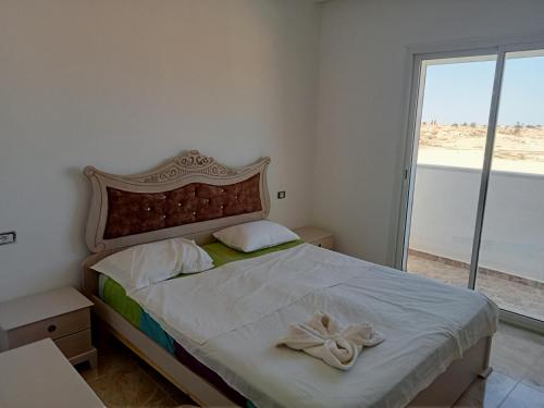 een slaapkamer met een groot bed en een groot raam bij Villa phare 2 in Midoun