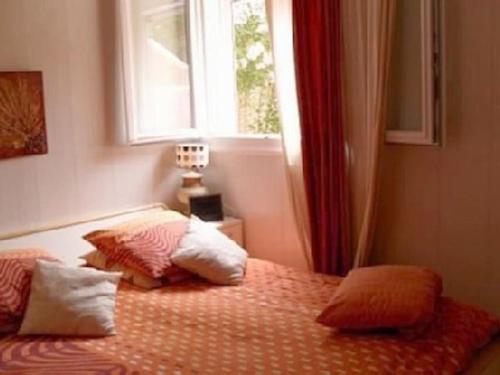 une chambre avec un lit avec des oreillers et une fenêtre dans l'établissement Magnifique appartement face à la plage de Beaucours, à Sanary-sur-Mer