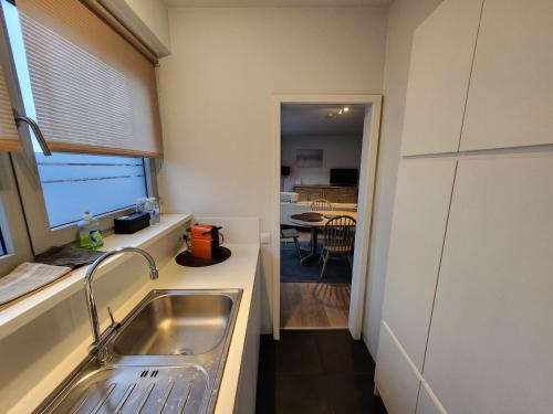 una cucina con lavandino e una sala da pranzo di Astrid - apartments a Mechelen