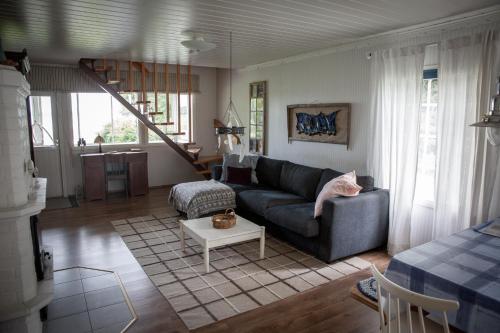 uma sala de estar com um sofá e uma mesa em Strömman mökki rannalla autotien päässä. 