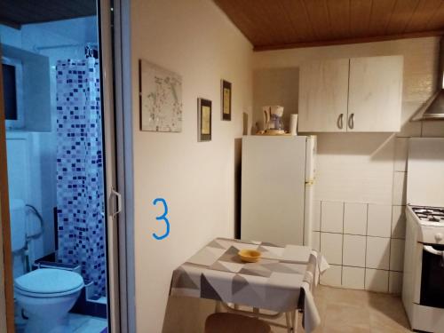 a small kitchen with a table and a refrigerator at Old Town Studio in Braşov