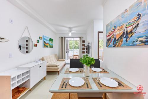 a white living room with a table and a couch at BH28: 1 Quadra d Praia, Ar, Churrasqueira, Piscina in Ubatuba