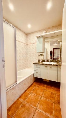 une salle de bain avec une baignoire et un lavabo dans l'établissement Ti Ma Zud/Vue mer/Wifi, à Camaret-sur-Mer