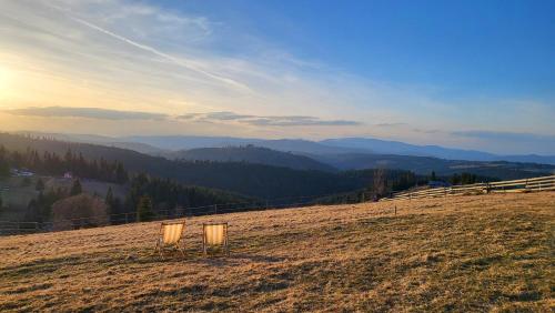 Dos luces sentadas en la cima de una colina con montañas. en Tiny House Casuta Schiorului 2, Mărișel Apuseni, en Mărişel