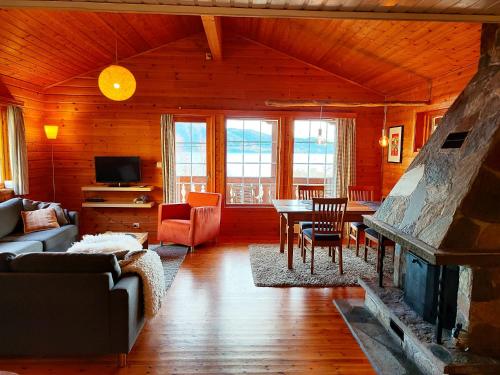 uma sala de estar com um sofá e uma lareira em Cosy chalet, 100m2 with fjordview! em Lauvstad
