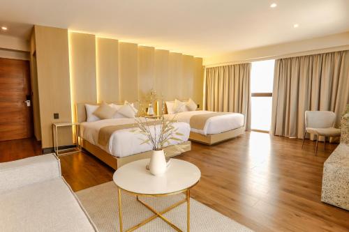 a hotel room with two beds and a table at Reforma Capital Inn in Mexico City