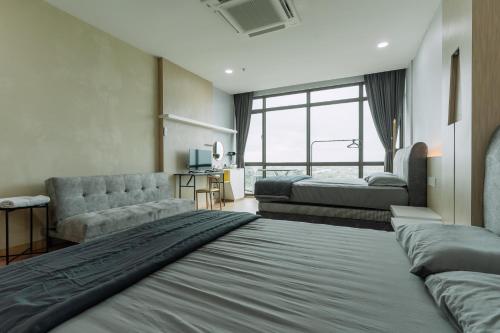 a hotel room with two beds and a couch at SUMMER SUITES APARTMENT CASETTA HOMESTAY 2 at Kota Samarahan Kuching in Kuching