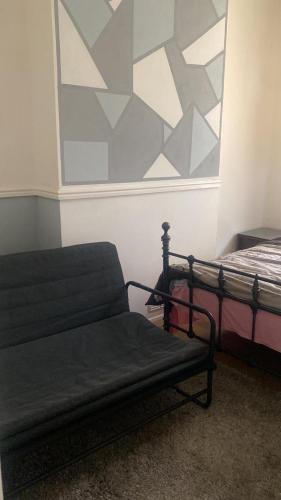 a room with a bed and a bench and a wall at first floor flat one bedroom in Hastings