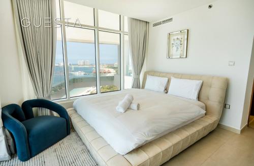 a large bed in a room with a large window at Azizi Mina The Palm, Free beach and pool access in Dubai