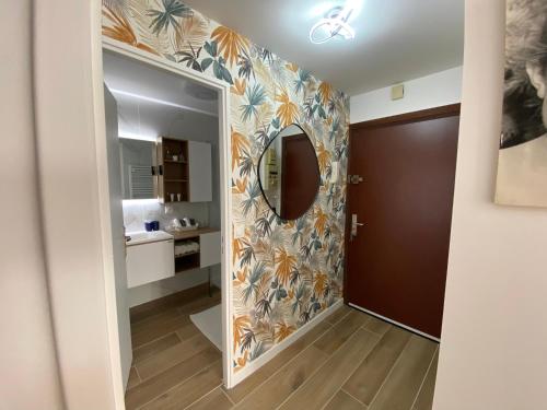 a hallway with a mirror and a bathroom at La Palmeraie 2 chambres in Sainte-Maxime