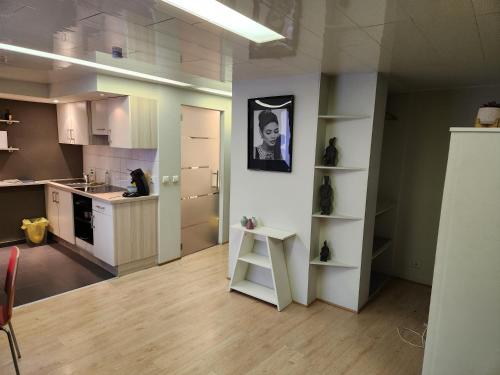 a kitchen with white cabinets and a stool in a room at Studio Astrid in Mechelen