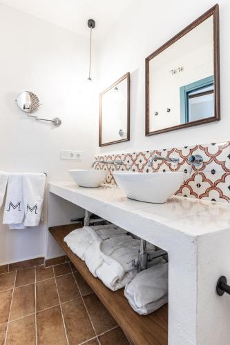 a bathroom with two sinks and two mirrors at Hospedium Hotel Rural Virgen María in Castilblanco de los Arroyos