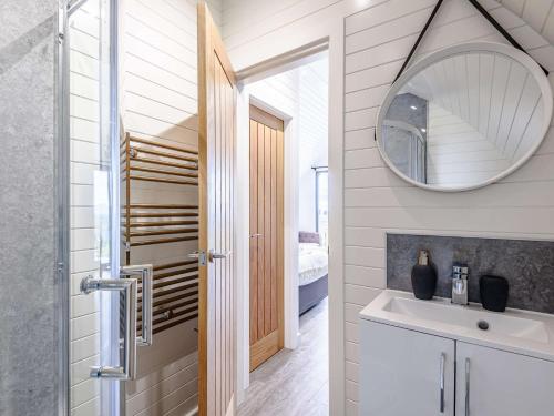 un bagno con lavandino e specchio di 1 Bed in Corwen 80321 a Gwyddelwern