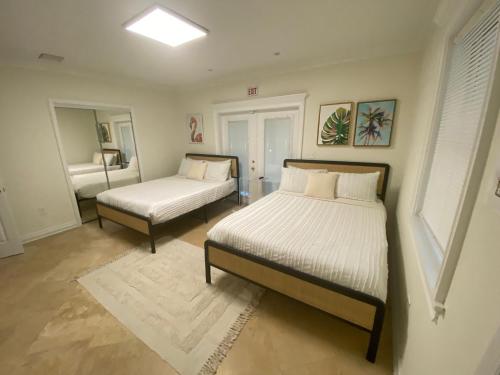 1 dormitorio con 2 camas y espejo en Entire home in Biscayne Park, Florida en Biscayne Park