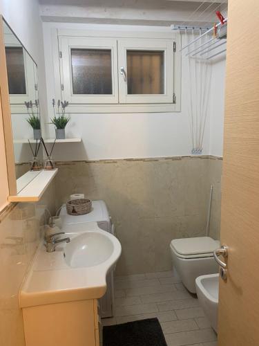 a bathroom with a sink and a toilet at Casa Antico Barbiere in Chioggia