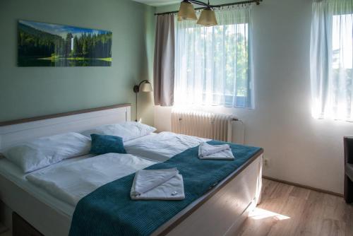 a bedroom with a bed with two towels on it at Penzion Horal in Osek