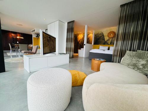 uma sala de estar com um sofá e uma televisão num quarto em Orange Lounge em Weyregg