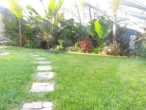 un patio de césped con un camino de piedra frente a un jardín en Villa anfa 3, en Casablanca