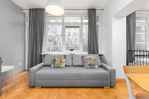 a gray couch in a living room with a window at Apartament Wspólna by Your Freedom in Warsaw