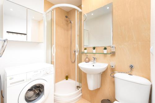 a bathroom with a washing machine and a sink at Apartament Wspólna by Your Freedom in Warsaw