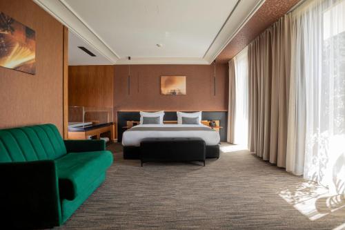 um quarto de hotel com uma cama e um sofá em Select Hill Resort em Tirana