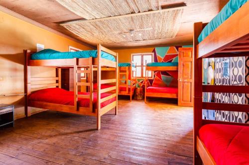 a room with three bunk beds in a house at Hostal Cosmo Elqui in Rivadavia