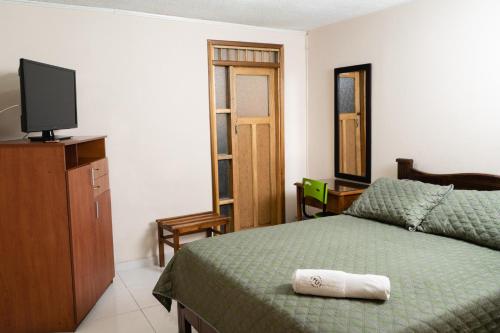 1 dormitorio con 1 cama y TV en un armario en Hotel Juanambu, en Pasto