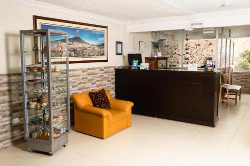 a waiting room with a yellow chair and a counter at Hotel Juanambu in Pasto