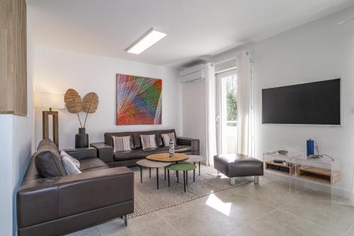 un salon avec un canapé et une télévision dans l'établissement Les Bergeronnettes - Piscine partagée proche plage, à Gujan-Mestras