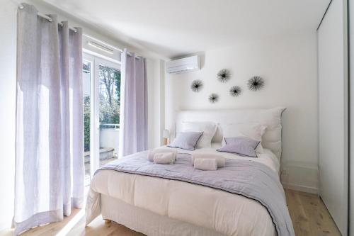 une chambre blanche avec un grand lit et une fenêtre dans l'établissement Les Bergeronnettes - Piscine partagée proche plage, à Gujan-Mestras