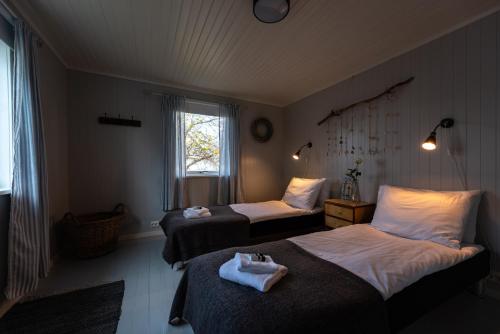a hotel room with two beds and a window at Cozy House By The Fjord In The Heart Of Lofoten in Reine