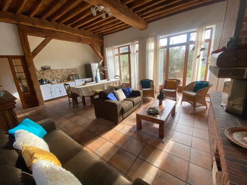 ein Wohnzimmer mit einem Sofa und einem Tisch in der Unterkunft Le Domaine de Toussacq in Villenauxe-la-Petite