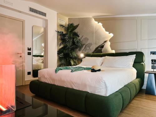 Amamare Luxury Room في جوليانوفا: غرفة نوم بسرير كبير مع أريكة خضراء