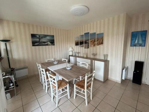 une salle à manger avec une table et des chaises en bois dans l'établissement Les Sables d'Olonne, villa de charme, conviviale, idéale en famille ou entre amis - jacuzzi intérieur, à Olonne-sur-Mer