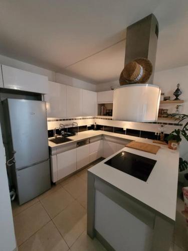 une cuisine avec des armoires blanches, un évier et un réfrigérateur dans l'établissement Gounod - Spacieux T2 - idéal pour couple, à Nice