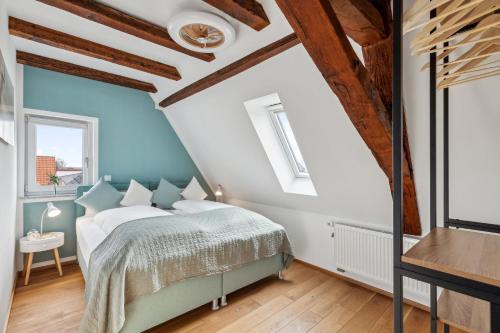 a bedroom with a bed with blue walls and wooden ceilings at Feuerstein - 2 BR-Appartment Smart-TV in Haßloch