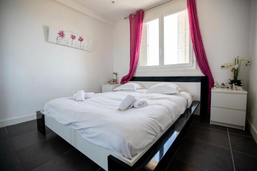 - une chambre avec un grand lit blanc et des rideaux rouges dans l'établissement Comfort 6 People Apartment by Connexion, à Cannes