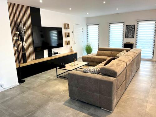 a living room with two couches and a flat screen tv at Villa accueillante à Millas avec piscine privée et jacuzzi in Millas
